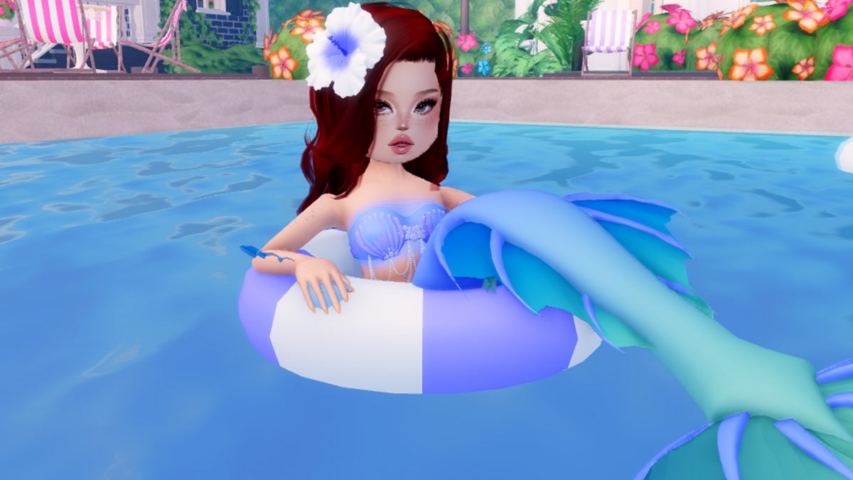 A screenshot of a mermaid laying in a pool ring in the pool in Dress to Impress in Roblox.